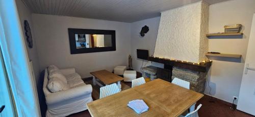 un salon avec une table et une cheminée dans l'établissement Pied des pistes app 5 personnes, à La Clusaz