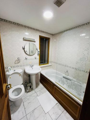 a bathroom with a toilet and a tub and a sink at George And Dragon Place in Chester