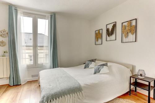 a bedroom with a white bed and a window at Le Courcillon Calme, Cour privée & Proche Château in Versailles
