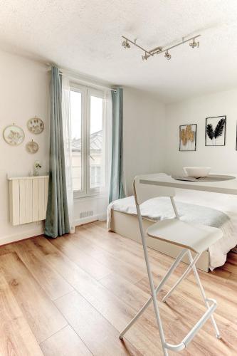 une chambre avec un lit et une chaise dedans dans l'établissement Le Courcillon Calme, Cour privée & Proche Château, à Versailles