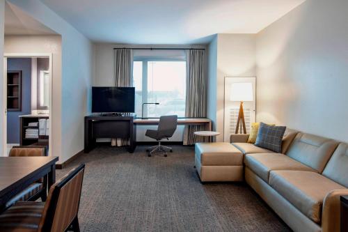 a living room with a couch and a desk at Residence Inn by Marriott Winnipeg in Winnipeg