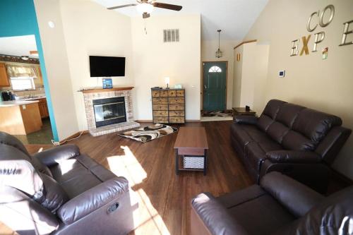 a living room with leather couches and a fireplace at Neighborhood ranch with parks, 3 miles to Purdue in West Lafayette