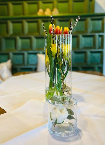 a vase filled with flowers sitting on a table at Hotel-Restaurant Kohlenbacher-Hof in Waldkirch