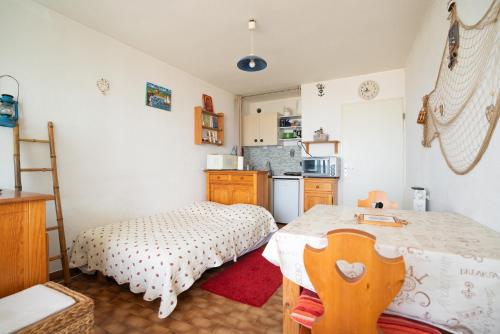 - une cuisine avec une table et un lit dans une chambre dans l'établissement Appartement face à la mer, à La Grande Motte