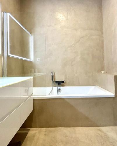 une salle de bain avec une baignoire et un lavabo dans l'établissement Appartement de Haut Standing Miomo, à Santa-Maria-di-Lota