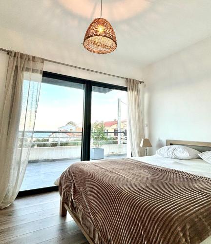 une chambre avec un lit et une grande fenêtre dans l'établissement Appartement de Haut Standing Miomo, à Santa-Maria-di-Lota