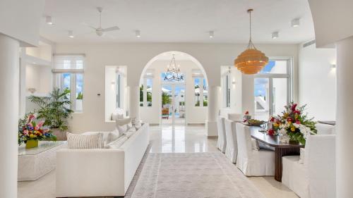 a living room with white furniture and a dining room at Aurora Anguilla Resort & Golf Club in Rendezvous Beach
