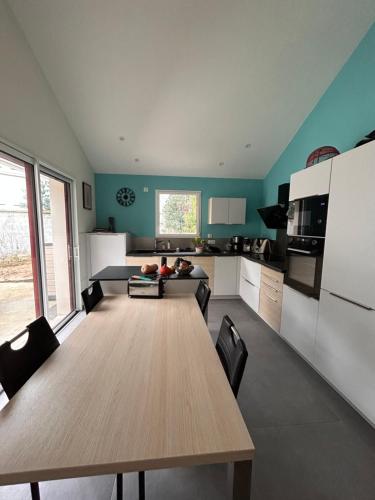 - une cuisine avec une grande table en bois dans l'établissement Charmante maison centre, à Saint-Brévin-lʼOcéan