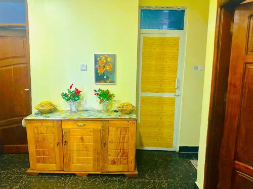a room with a wooden cabinet with flowers on it at Central Beautiful & peaceful Private bedroom AC, Very fast WiFi in Dar es Salaam