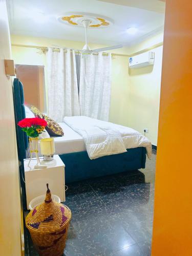 a bedroom with a bed and a flower vase on a table at Central Beautiful & peaceful Private bedroom AC, Very fast WiFi in Dar es Salaam