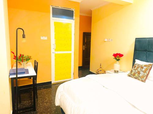 a bedroom with a bed and a desk and a window at Central Beautiful & peaceful Private bedroom AC, Very fast WiFi in Dar es Salaam