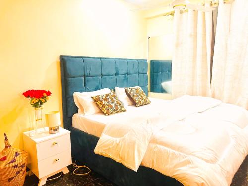 une chambre avec un grand lit avec une tête de lit bleue dans l'établissement Central Beautiful & peaceful Private bedroom AC, Very fast WiFi, à Dar es Salaam