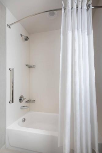a bathroom with a white shower curtain and a tub at Residence Inn Waco South in Waco