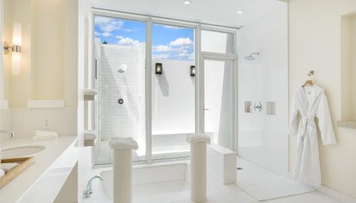 a white bathroom with a tub and a shower at Aurora Anguilla Resort & Golf Club in Rendezvous Beach