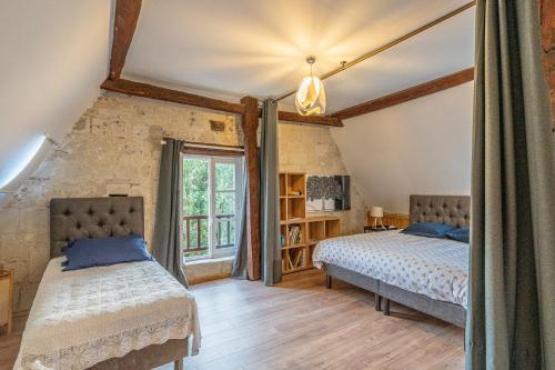 une chambre avec deux lits et une fenêtre dans l'établissement Léonard, à Saumur