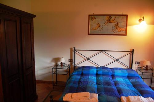 a bedroom with a bed with a blue comforter at Borgo Nuovo San Martino in Ambra