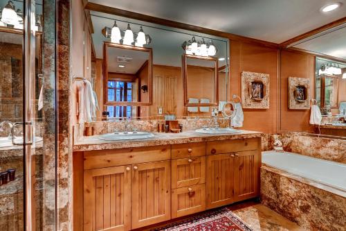 a bathroom with two sinks and a bath tub and a tubermott at Bachelor Gulch Village by Vail Resorts in Avon