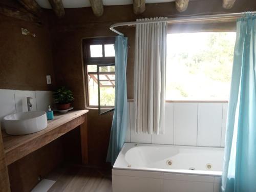a bathroom with a tub and a sink and a window at Tierra Colibrí in Punta Colorada