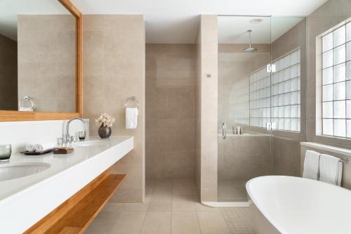 a bathroom with a tub and a sink and a shower at Aurora Anguilla Resort & Golf Club in Rendezvous Beach