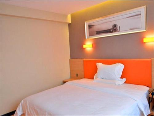 a bedroom with a white bed with an orange headboard at IU Hotel Beijing West Coach Station Liuliqiao East Metro Station in Beijing