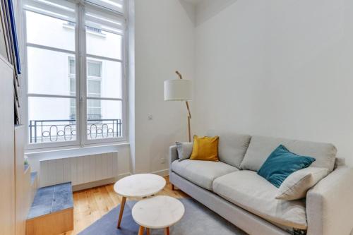 un salon avec un canapé et deux tables dans l'établissement Flexliving - One bedroom apartment - Bretagne, à Paris