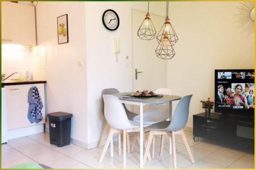 Una cocina y un comedor con mesa y sillas. en Le Lodge Central - Parking - Vue Piscine - By Montauban City, en Montauban