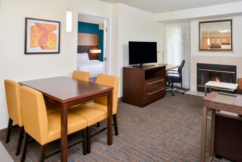 a hotel room with a desk and a dining room at Residence Inn by Marriott Branson in Branson