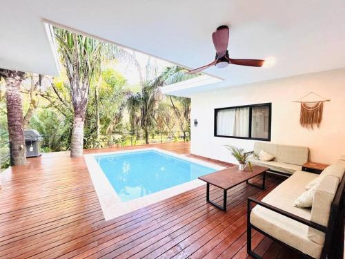 a living room with a pool and a ceiling fan at Cosmos House in the Jungle in Santa Teresa Beach