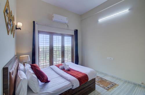 a bedroom with a large bed with a window at TAJ VILLA Mahabaleshwar ! in Mahabaleshwar