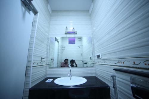 a person taking a picture of a bathroom sink at Vijaya Residency - Porur in Chennai