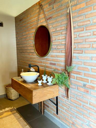 a bathroom with a sink and a brick wall at Sítio Santo Antônio in Piracicaba