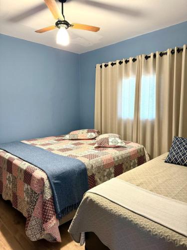 a bedroom with two beds and a ceiling fan at Sítio Santo Antônio in Piracicaba