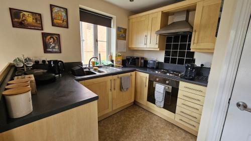 a kitchen with wooden cabinets and black counter tops at Cosy York Apartment in York