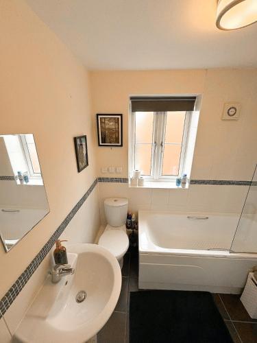 a bathroom with a sink and a toilet and a tub at Cosy York Apartment in York
