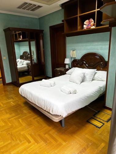 a bedroom with a large bed and a mirror at Habitación Centro de Oviedo in Oviedo