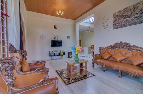 a living room with a couch and a table at TAJ VILLA Mahabaleshwar ! in Mahabaleshwar