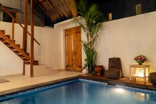 una piscina en una habitación con una casa en Agatha Villa Canggu, en Canggu