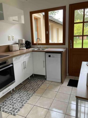 une cuisine avec un évier et une cuisinière four supérieur dans l'établissement Le refuge cosy Amiens, à Saleux