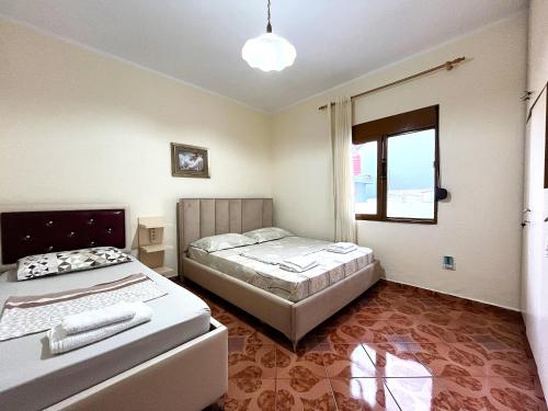 a bedroom with two beds and a window at Beach & Chill Apartments in Vlorë
