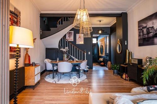 un salon avec une table et un escalier dans l'établissement Maison avec terrasse parfaite pour les 24H et GP Moto, au Mans