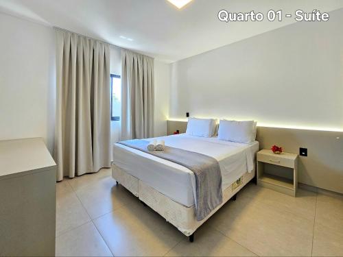 een slaapkamer met een groot wit bed en een raam bij Sobrado novíssimo 3 quartos melhor bairro de foz in Foz do Iguaçu