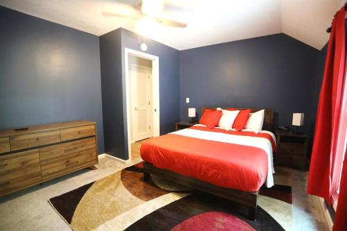 a bedroom with a red bed and blue walls at Purdue Bell Tower views, Central WL location, Walk 2 Purdue in West Lafayette