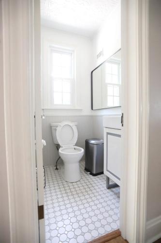 a white bathroom with a toilet and a mirror at Purdue Bell Tower views, Central WL location, Walk 2 Purdue in West Lafayette