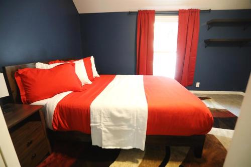 a bedroom with a red and white bed with a window at Purdue Bell Tower views, Central WL location, Walk 2 Purdue in West Lafayette