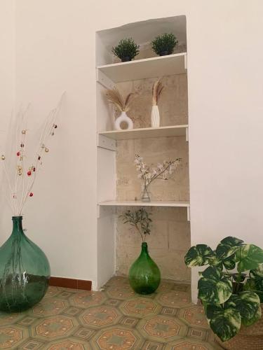 zwei grüne Vasen auf Regalen in einem Raum in der Unterkunft Dimora Pugliese in Bari