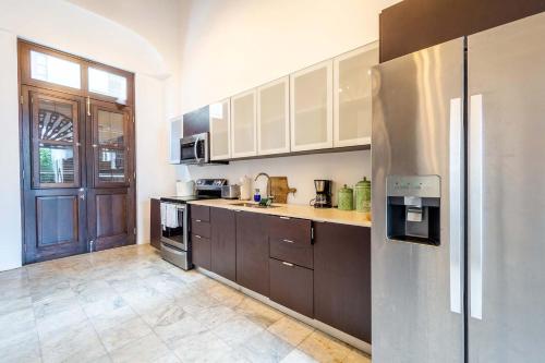 a kitchen with brown cabinets and a stainless steel refrigerator at 150 Sol by Stay with Bear in San Juan