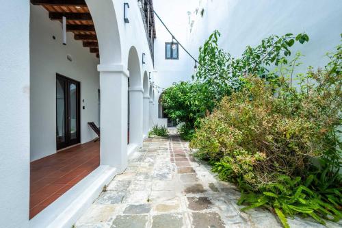 an alleyway of a house with white walls at 150 Sol by Stay with Bear in San Juan