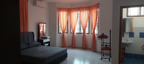 a bedroom with orange curtains and a bed and a sink at Skudai close to JB Town Corner House in Johor Bahru