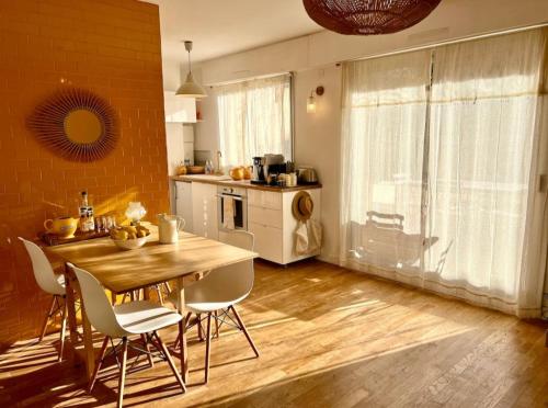 - une cuisine avec une table et des chaises en bois dans la chambre dans l'établissement Face à la plage STUDIO avec grande terrasse au calme, à Marseille