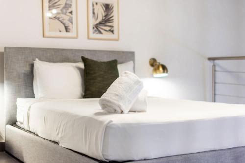 a bed with white sheets and pillows in a bedroom at Casa Las Ruinas by Stay with Bear in San Juan